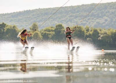 zwei weibliche Wasserski Fahrer gleiten auf dem See