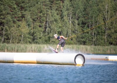 Wakeboarder slidet rückwärts auf einem Slider, der im Wasser schwimmt