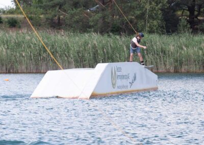Junger Wakeboarder slidet auf der Abfahrt einer Funbox