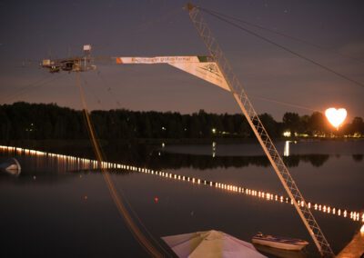 Wasserskianlage bei Nacht mit romantischer Beleuchtung auf dem Steg