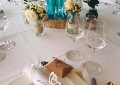Hochzeitlich geschmückter Tisch mit Wasserflaschen und Gläsern