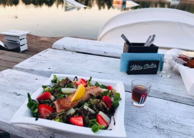 Lachs mit Erdbeeren und Salat auf einem Teller mit Blick auf den See