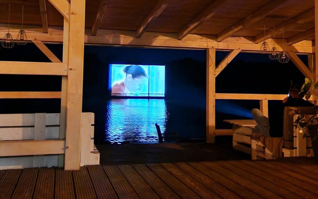 luftgepolsterte Leinwand steht im Wasser, worauf ein Film projiziert wird