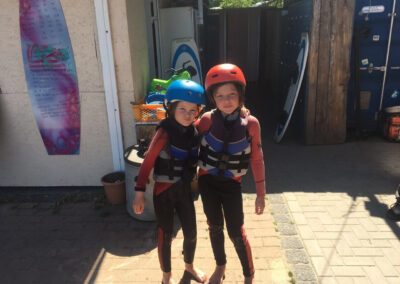 Zwei Wassersport Mädchen im Neoprenanzug freuen sich
