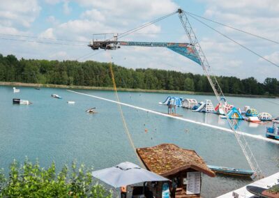 Mast der Wasserski- und Wakeboardanlage mit Blick auf den Aquapark im See